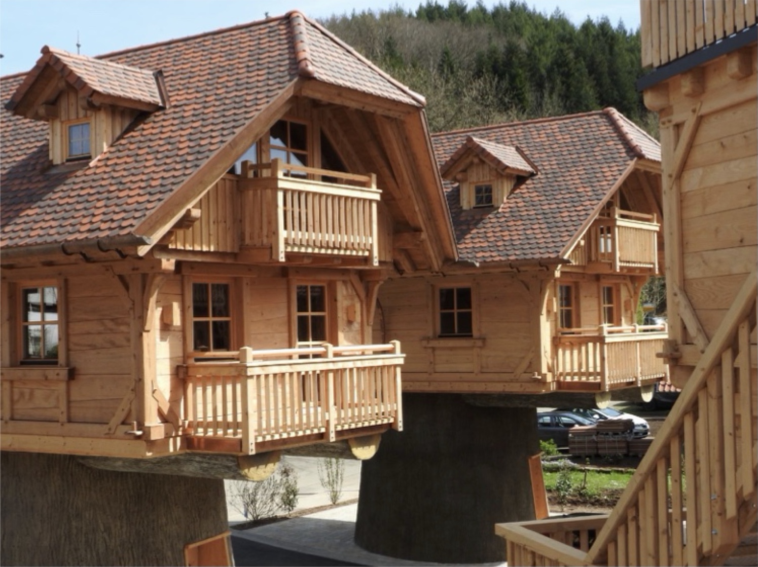Baumhäuser aus Holz auf Stelzen am SPA-Campingplatz Seelbach, mit Balkonen und Ziegeldächern.