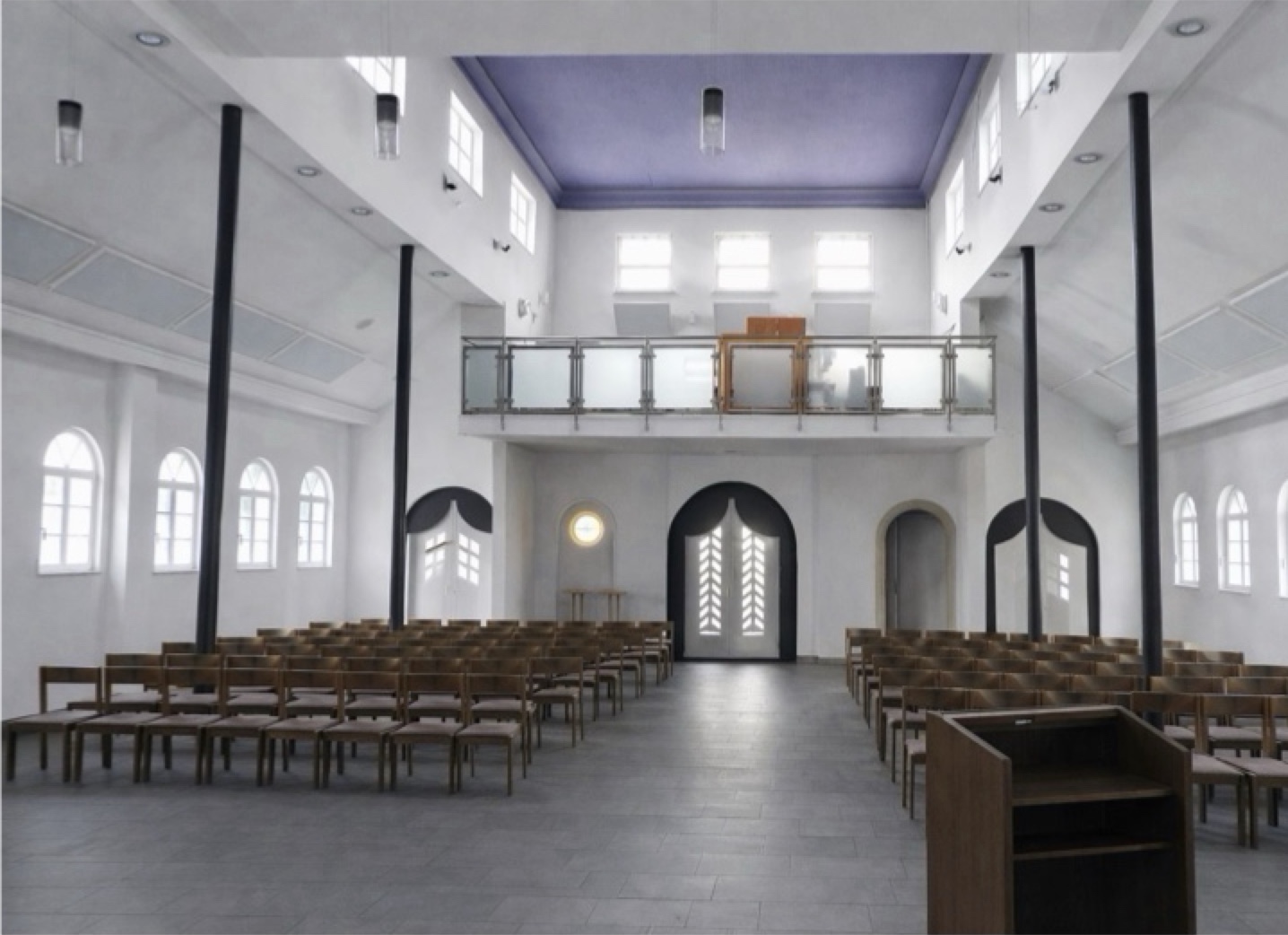 Innenraum einer Aussegnungshalle mit leeren Stuhlreihen, hohen Rundbogenfenstern und heller Decke.