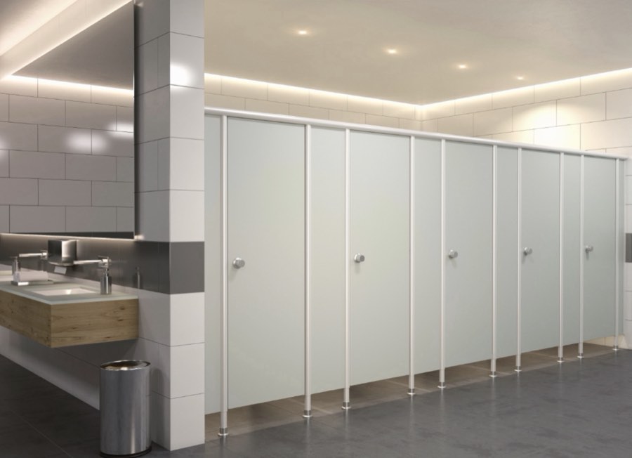 Sanitärbereich mit weißen WC-Trennwänden, Waschtisch aus Holz und indirekter Deckenbeleuchtung.
